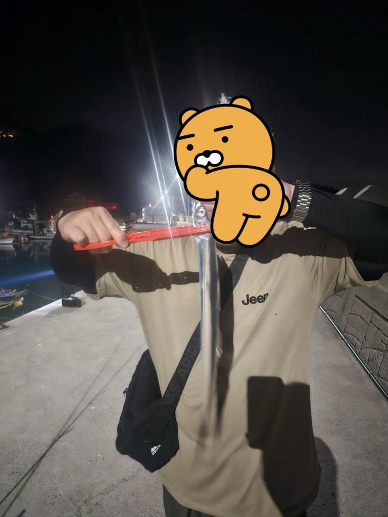 평산방파제에서 잡은 갈치를 들어 보인 모습